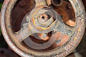 Old rusty faucet crane. Round handle of water supply valve close-up