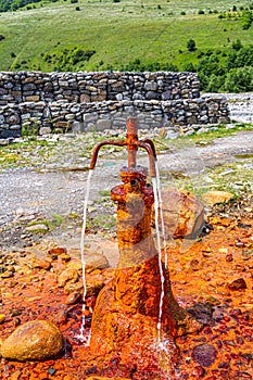 Old rusty faucet with natural, carbonated, mineralized water rich in sulfur and metal