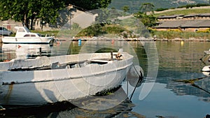 Old rusty fishing boat stands moored to the pier.