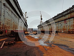 Old rusty floating dry dock. Dry docks are used for the construction, maintenance and repair of ships. Murmansk. Tall