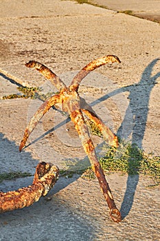 Old rusty four-legged anchor in the seaport