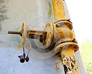 An old rusty gas control valve on the wall photo