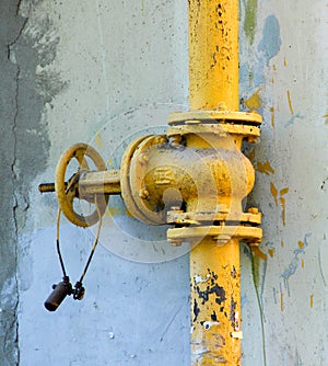 An old rusty gas control valve on the wall photo