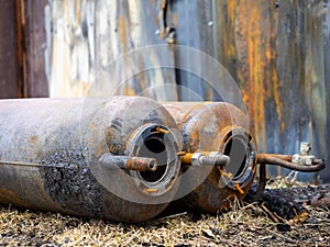 Old rusty gas cylinders lie on the ground, close-up. Dangerous cylinders as the cause of explosions and fires. Industrial