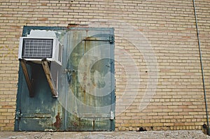 A old rusty green door with a ac unit at the old factory