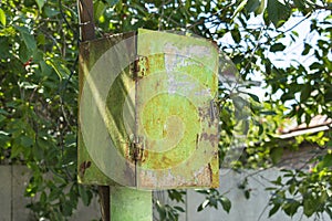 Old rusty green peeling metal postal box (junction box) under th