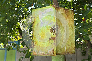 Old rusty green peeling metal postal box (junction box) under th