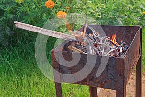 In an old rusty grill for cooking in the street is burning fire