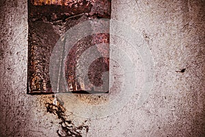 An old rusty gutter old pipe next to a wall