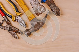 Old and rusty hand tools . Work background on wooden board