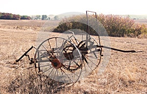 Old rusty hay turner on a field