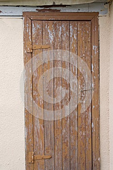 Old rusty hinges on brown wooden cracked door close up