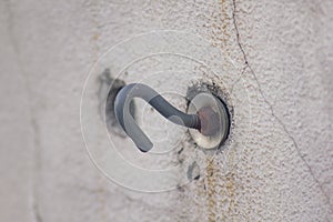 Old rusted hooks on white walls.