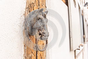 Old rusty horse's head with a ring for tying horses in a backyard photo