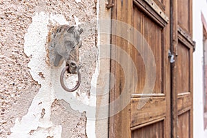 Old rusty horse's head with a ring for tying horses in a backyard