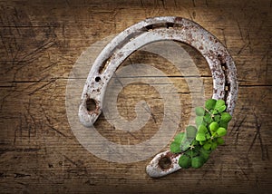 Old rusty horseshoe and four leaf clover