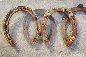 Old rusty horseshoe on a grey stone background. Good luck symbol. Vintage concept.