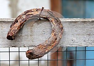 Old rusty horseshoe hanging on a nail