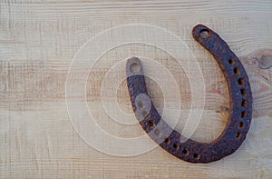 Old rusty horseshoe on a pine board. Natural wood background. Wood texture. Place for text