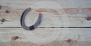 Old rusty horseshoe on a pine board. Natural wood background. Wood texture. Place for text