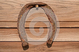 Old rusty horseshoe on vintage wooden board