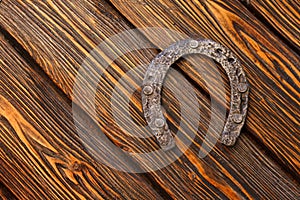 Old rusty horseshoe on vintage wooden board