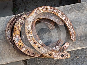 Old rusty horseshoe on a wooden background. Good luck symbol. Vintage concept.