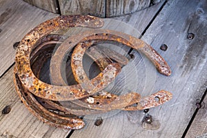 Old rusty horseshoe on a wooden background. Good luck symbol. Vintage concept.