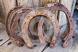 Old rusty horseshoe on a wooden background. Good luck symbol. Vintage concept.