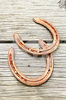 Old rusty horseshoe on wooden board