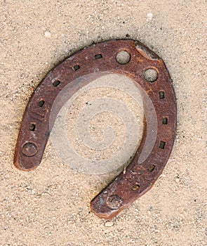 Old rusty horseshoes on sand