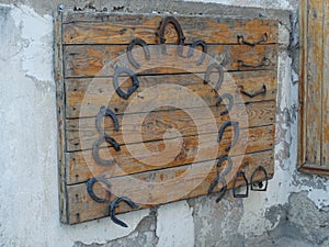 Old rusty horseshoes and stirrups on a wooden background