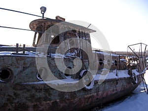 Old rusty hull of a sunken ship on the shore