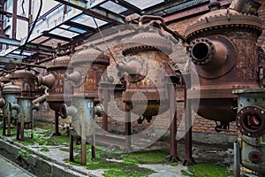 Old rusty industrial containers in abandoned chemical factory