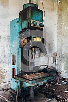 Old rusty industrial drilling machine in abandoned factory workshop looks like robot