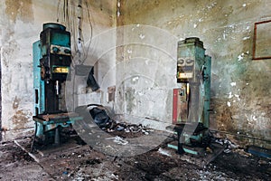Old rusty industrial drilling machine tools in abandoned factory workshop looks like robots