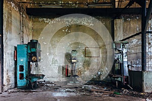 Old rusty industrial drilling machine tools in abandoned factory workshop looks like robots