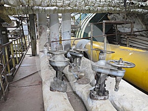 Old rusty industrial steel pipelines, valves and equipment at po