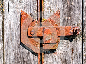 Old rusty iron bolt of a wooden gate lock