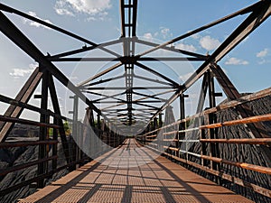 Old, rusty iron bridge for crossing over the rails