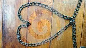 Old and rusty iron chain on a wooden background