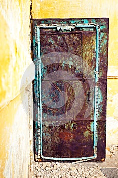 Old rusty iron door in the abandoned concrete house