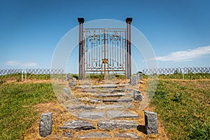 Old rusty iron gate in the middle of a field leading to nowhere. Concept of purgatory, limits, frontiers and freedom