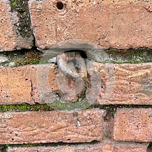 Old rusty iron hook in a brick wall