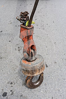 Old and rusty iron hook standing on concrete floor