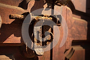 Old rusty iron latch on a wooden door