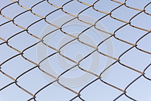 Old and rusty iron net wrapped on blue sky background