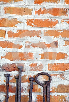 Old rusty iron scrap standing on the background of a brick wall