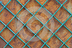 Old rusty iron wall behind a metal painted lattice