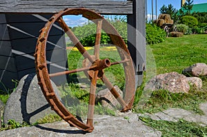 Old rusty iron wheel on a green field